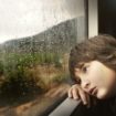 kid waiting by rainy window
